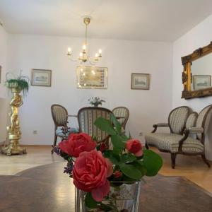 a vase with roses on a table in a living room at Amadeus Apartment in Baden
