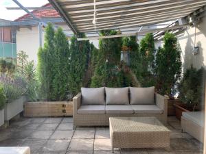 a couch on a patio with a wall of plants at Amadeus Apartment in Baden
