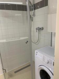 uma máquina de lavar roupa na casa de banho com um chuveiro em Amadeus Apartment em Baden