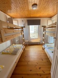 a room with two bunk beds and a wooden ceiling at JACOB'S HOSTEL TUI in Tui