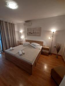 um quarto com uma cama grande e 2 candeeiros em Apartments Adria em Jadrija