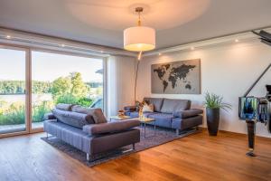 a living room with two couches and a large window at Inspiration am See in Bad Endorf