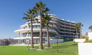 un bâtiment avec des palmiers en face de celui-ci dans l'établissement Infinity View Lovely Apartment, à Arenales del Sol