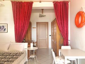 a room with red curtains and a bed and a table at Stars Home in Tropea