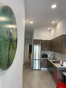 a kitchen with stainless steel appliances and a painting on the wall at T-Homes - Fuencarral in Madrid