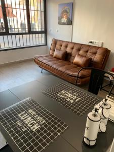 sala de estar con sofá marrón y 2 esteras en T-Homes - Fuencarral en Madrid