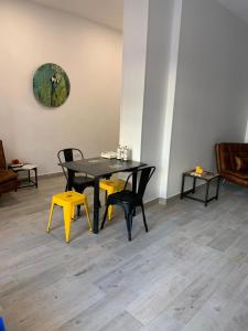 a dining room with a black table and yellow chairs at T-Homes - Fuencarral in Madrid