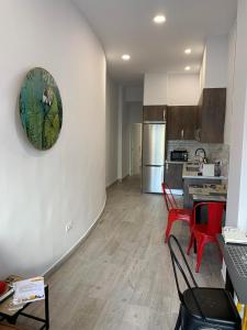 a living room with a kitchen with red chairs at T-Homes - Fuencarral in Madrid