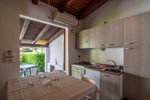 eine Küche mit einem Tisch, einer Spüle und einem Herd in der Unterkunft Residence Punta Spin in Grado