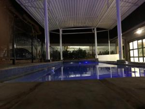 PW Heights Private Guest House في ثوهوياندو: مسبح فارغ في مبنى في الليل