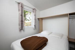 a bedroom with a bed with a brown blanket on it at Camping La Belle Etoile in Melun +38 photos