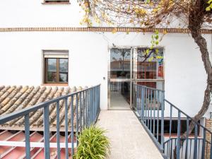 ein weißes Haus mit einem blauen Geländer und einer Tür in der Unterkunft Hostal Santiago in Écija
