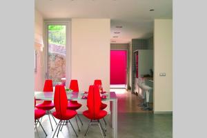uma sala de jantar com cadeiras vermelhas e uma mesa em CasadelaLuzBenicasim, diseño y lujo em Oropesa del Mar