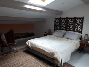 1 dormitorio con 1 cama blanca grande y tragaluz en La Villa des Ames Liées, en Draguignan