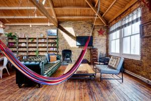 a hammock in a room with a couch and chairs at Penthouse Loft apartment with roof terrace Not for events or parties in London