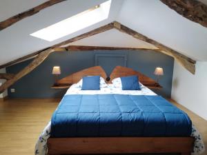 sypialnia z dużym łóżkiem z niebieskimi poduszkami w obiekcie A deux pas de St Cirq Lapopie , Gite des Murets de l'isa w mieście Esclauzels