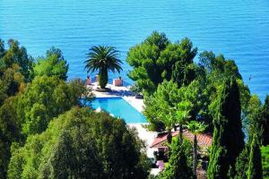 einen Luftblick auf einen Pool neben dem Meer in der Unterkunft Excelsior Palace Hotel in Taormina