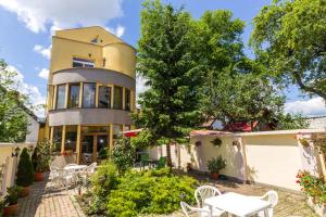 a building with tables and chairs in front of it at PENSIUNEA HORA in Braşov