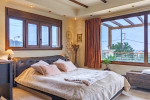a bedroom with a large bed and a large window at Colonial View Apartment in Faliraki
