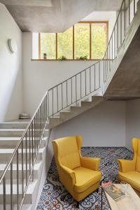 two yellow chairs in a living room with stairs at Cett in Náměšť nad Oslavou