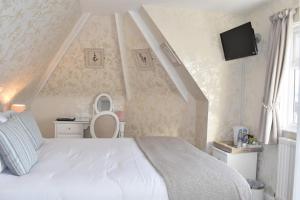 a bedroom with a white bed and a staircase at The Castleton in Swanage