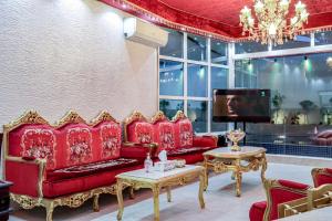 a living room with red couches and a tv at Staycation Home Shj in Sharjah