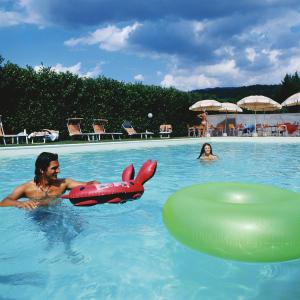 a man in a swimming pool with an inflatable at Hotel Ristorante La Lanterna in Castelnuovo di Garfagnana