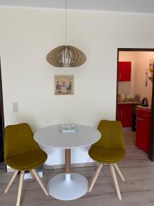 uma mesa e duas cadeiras num quarto em Lichtdurchflutetes Apartment mit Blick ins Grüne em Mülheim an der Ruhr