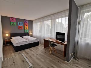 Schlafzimmer mit einem Bett und einem Schreibtisch mit einem Computer in der Unterkunft Plaza Inn Hannover City Nord in Hannover