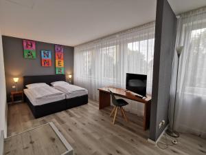 1 dormitorio con 1 cama y escritorio con ordenador en Plaza Inn Hannover City Nord, en Hannover