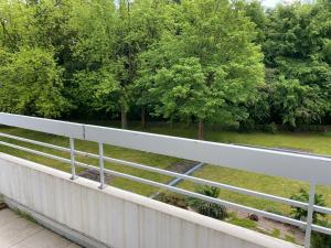 uma cerca branca com árvores num campo em Lichtdurchflutetes Apartment mit Blick ins Grüne em Mülheim an der Ruhr