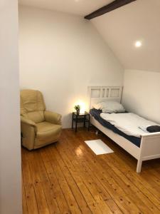 ein Schlafzimmer mit einem Bett und einem Stuhl in der Unterkunft Monteurhaus 6 Zimmer in Worms