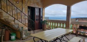 einen Holztisch auf einem Balkon mit Tür in der Unterkunft Casa Linda e Arejada in São Thomé das Letras