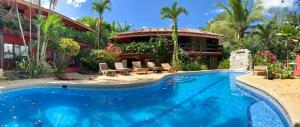 a swimming pool in front of a house at Massai Apartments in Playa Flamingo