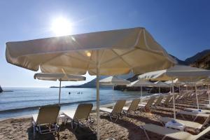 a group of chairs and umbrellas on a beach at Bali Star Resort Hotel in Bali