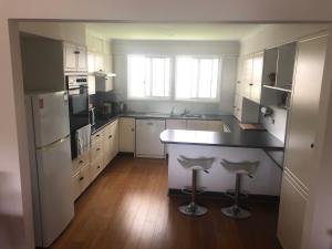 a kitchen with white cabinets and a black counter top at House Beside The Lake in Summerland Point