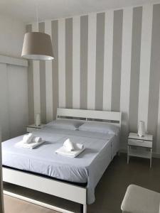 - une chambre avec un grand lit et 2 serviettes dans l'établissement VIRVIT CASA VACANZE, à Porto Cesareo
