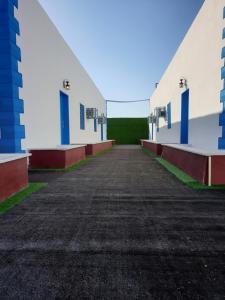 een lege parkeerplaats tussen twee witte gebouwen bij شقق سانتوريني الخاصة Santorini Private Apartments in Al Ula