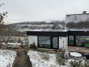 una casa con nieve en el suelo delante de ella en Ferienwohnung Limes, en Aalen