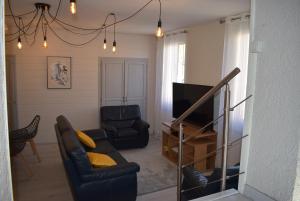 - un salon avec deux chaises et une télévision dans l'établissement Maison de charme dans le Gers, à Noilhan