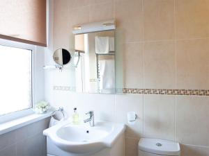 a bathroom with a sink and a toilet and a mirror at The Castleton in Swanage