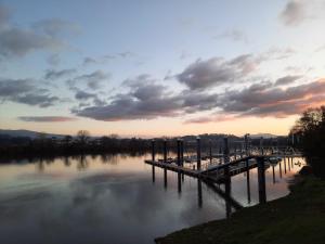 a dock on a lake with a cloudy sky at JACOB'S HOSTEL TUI in Tui