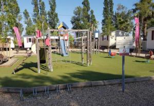 a park with a playground with a slide at Mobilhome beaux volumes ES40 in Fréjus