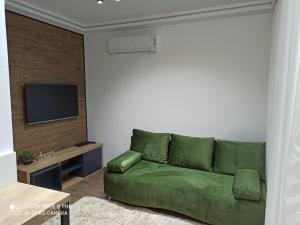 a green couch in a living room with a television at Apartments Breza in Zlatibor