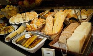 a display case with various types of bread and cheese at Primme Hotel Aracaju in Aracaju