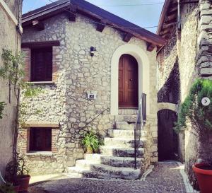a stone house with stairs leading to a door at B&B Leofreni Natura in Leofreni