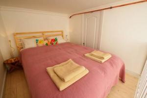 a bedroom with a pink bed with two towels on it at ORANGEHOMES two bedroom apartment Ráday str. in Budapest