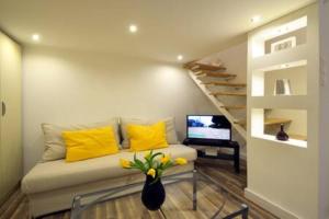 a living room with a couch with yellow pillows at ORANGEHOMES two bedroom apartment Ráday str. in Budapest