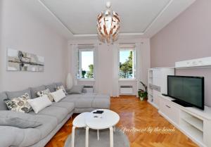 a living room with a couch and a tv at Apartman Nikki Kolovare Beach in Zadar