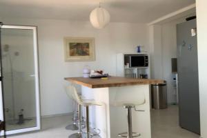 een keuken met een aanrecht en krukken in een kamer bij Petit coin de paradis in Rayol-Canadel-sur-Mer